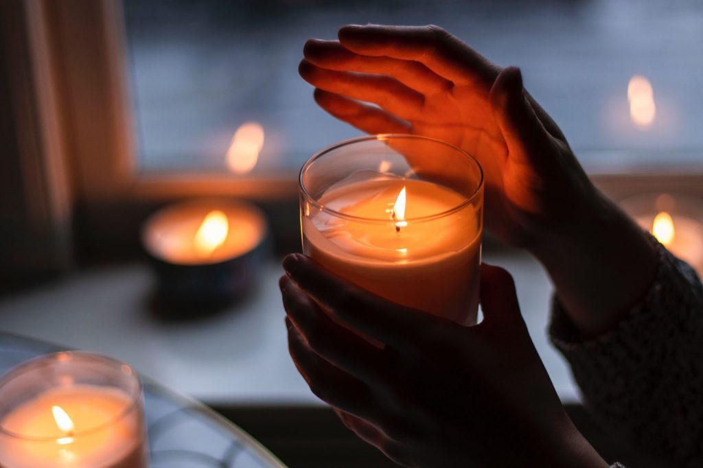 person holding small candle during power outage